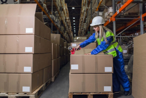 a girl marks boxes in a warehouse