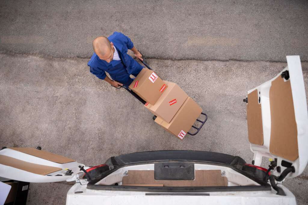 a courier carries boxes on a cart