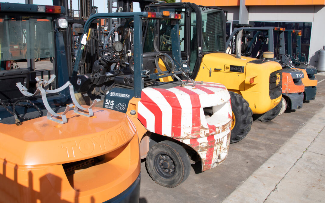 Lineup of Forklift Trucks in Various Shades of Orange