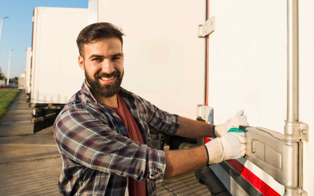 A smiling Class 5 dangerous goods transporter in Australia shuts the doors of his truck.